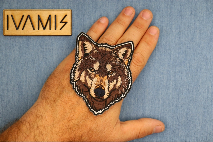 Staring Wolf Patch shown on hand for size comparison
