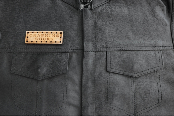 Crashing Sucks Oak Wood Patch shown on leather vest