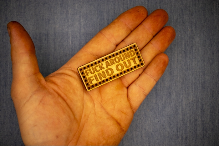 Fuck Around Find Out Wood Patch shown on hand for size comparison