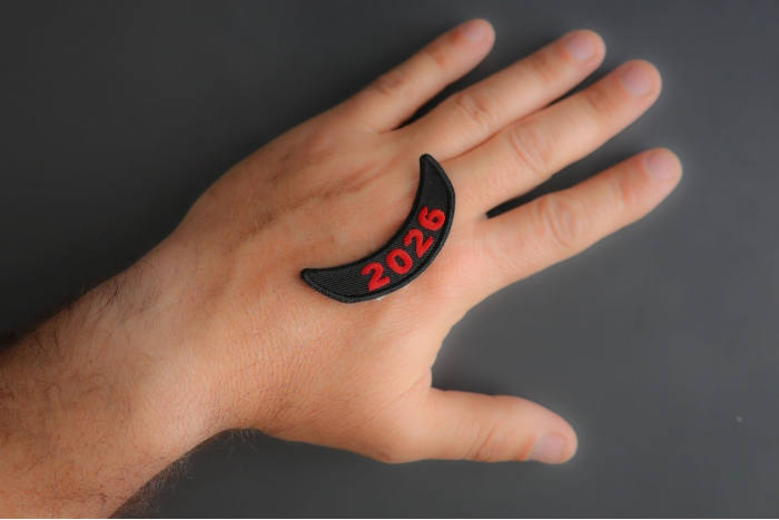 2026 Lower Rocker Red Year Patch shown on hand for size comparison