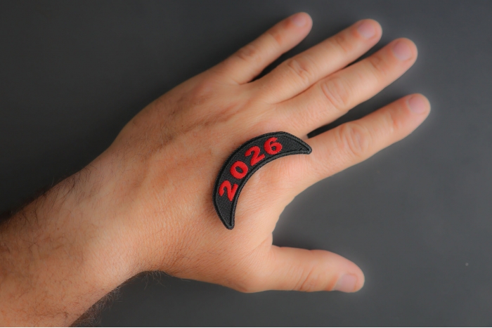 2026 Upper Rocker Red Year Patch shown on hand for size comparison