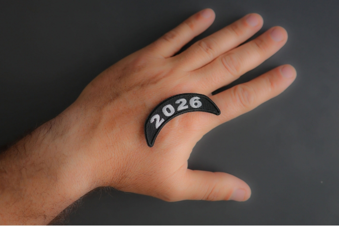 2026 Upper Rocker White Year Patch shown on hand for size comparison