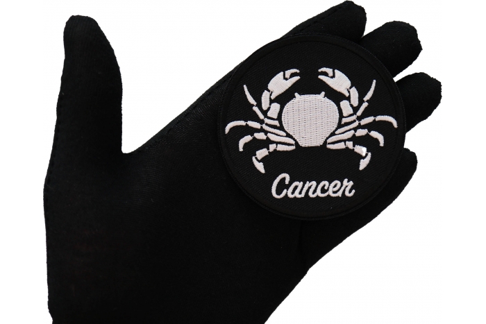 Cancer zodiac sign shown on hand for size comparison