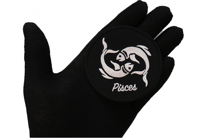 Pisces zodiac sign shown on hand for size comparison