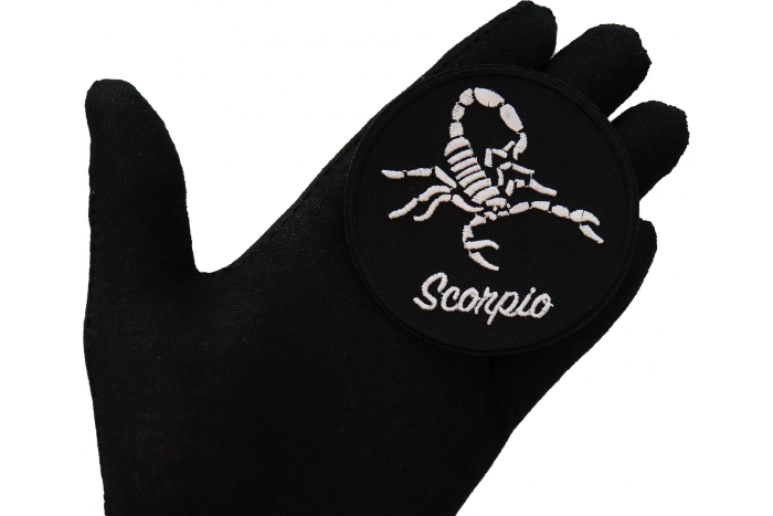 Scorpio zodiac sign shown on hand for size comparison