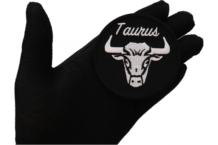 Taurus zodiac sign shown on hand for size comparison
